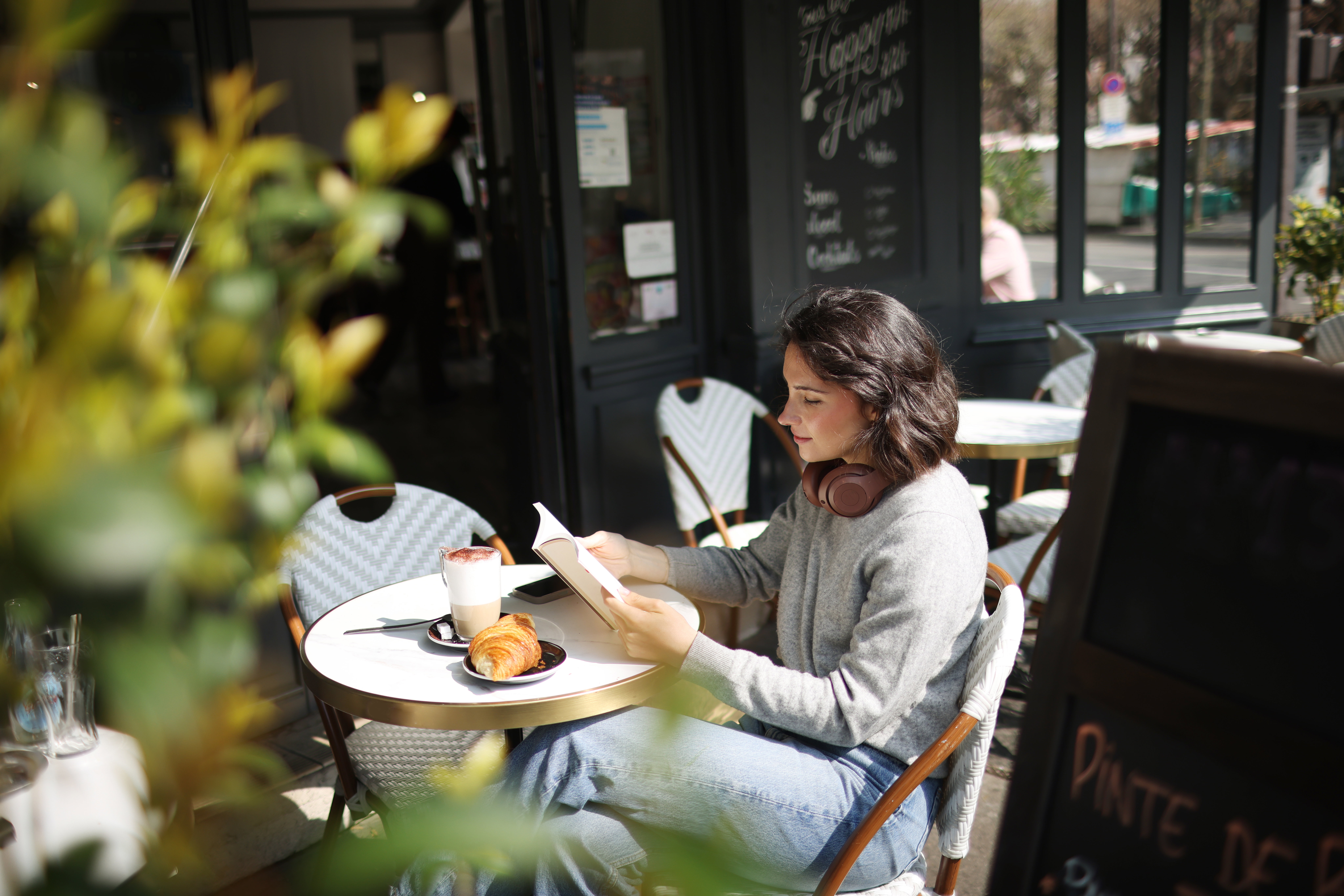 A young woman sitting on a Parisian café terrace