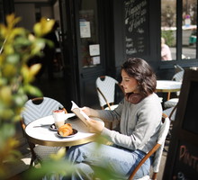A young woman sitting on a Parisian café terrace