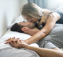 The young couple kissing in the bed