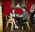 Smiling couple in discussion while seated at table in night club