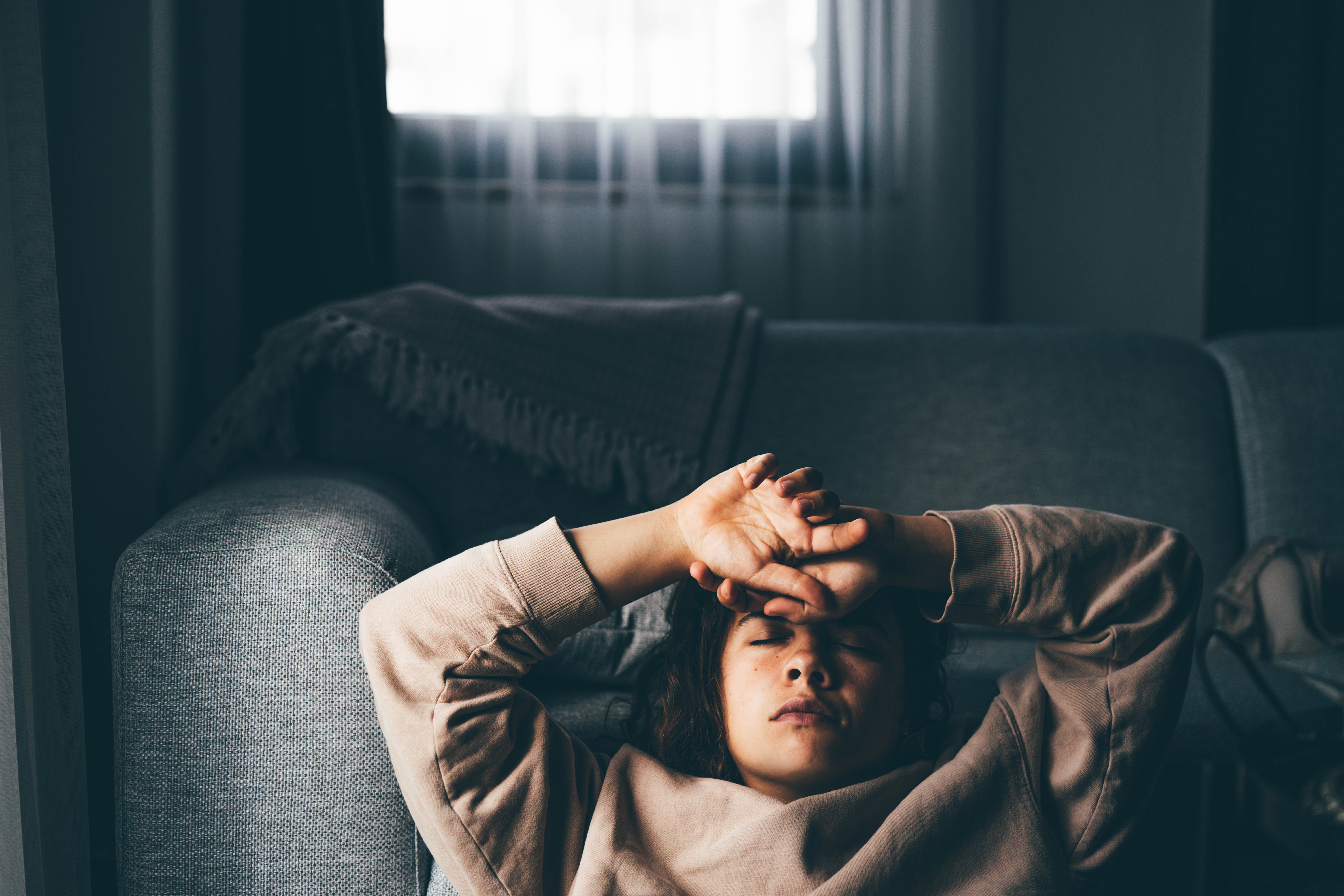 Sad and depressed  woman sitting on sofa at home.