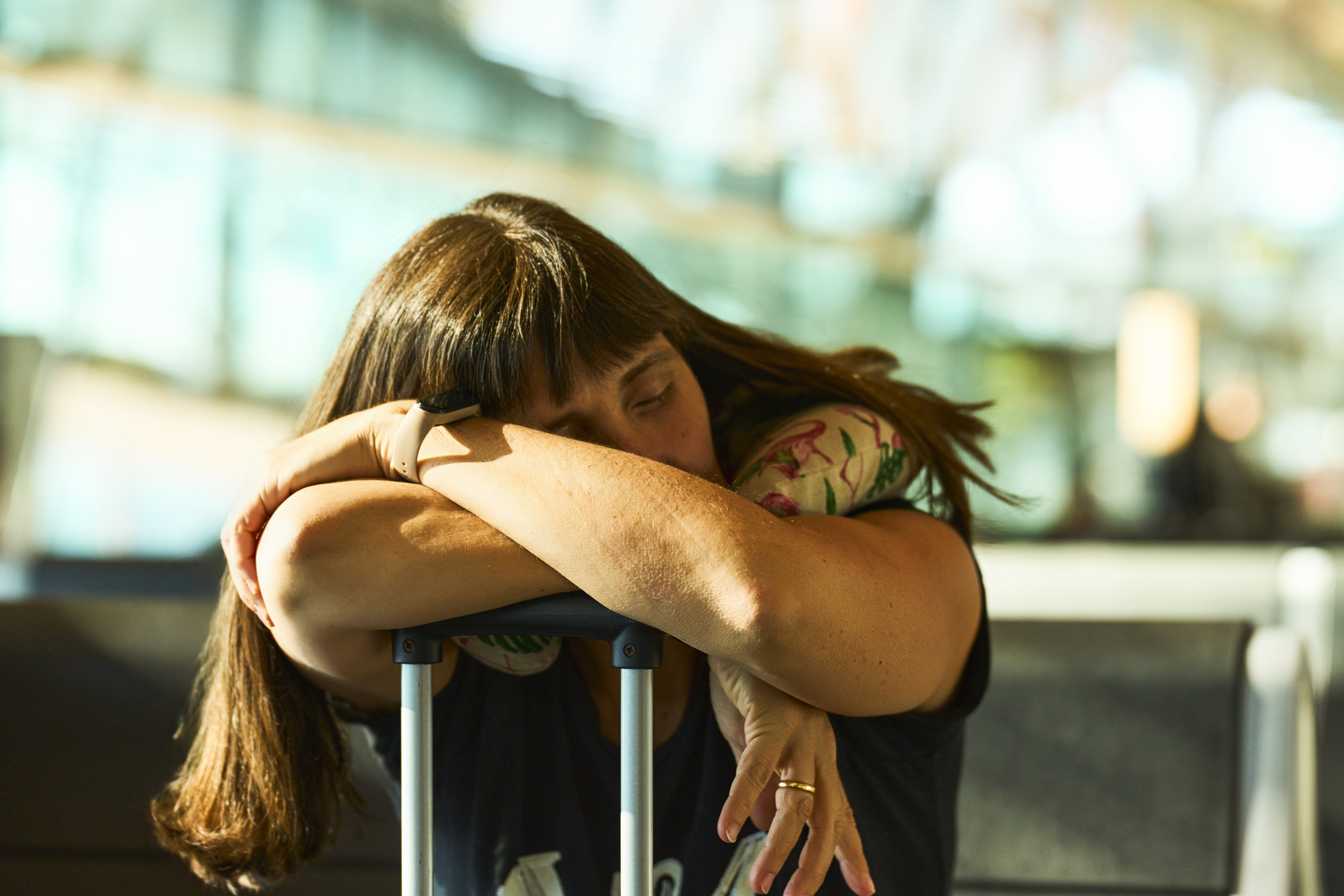 Mid adult woman sleeping in airport while traveling