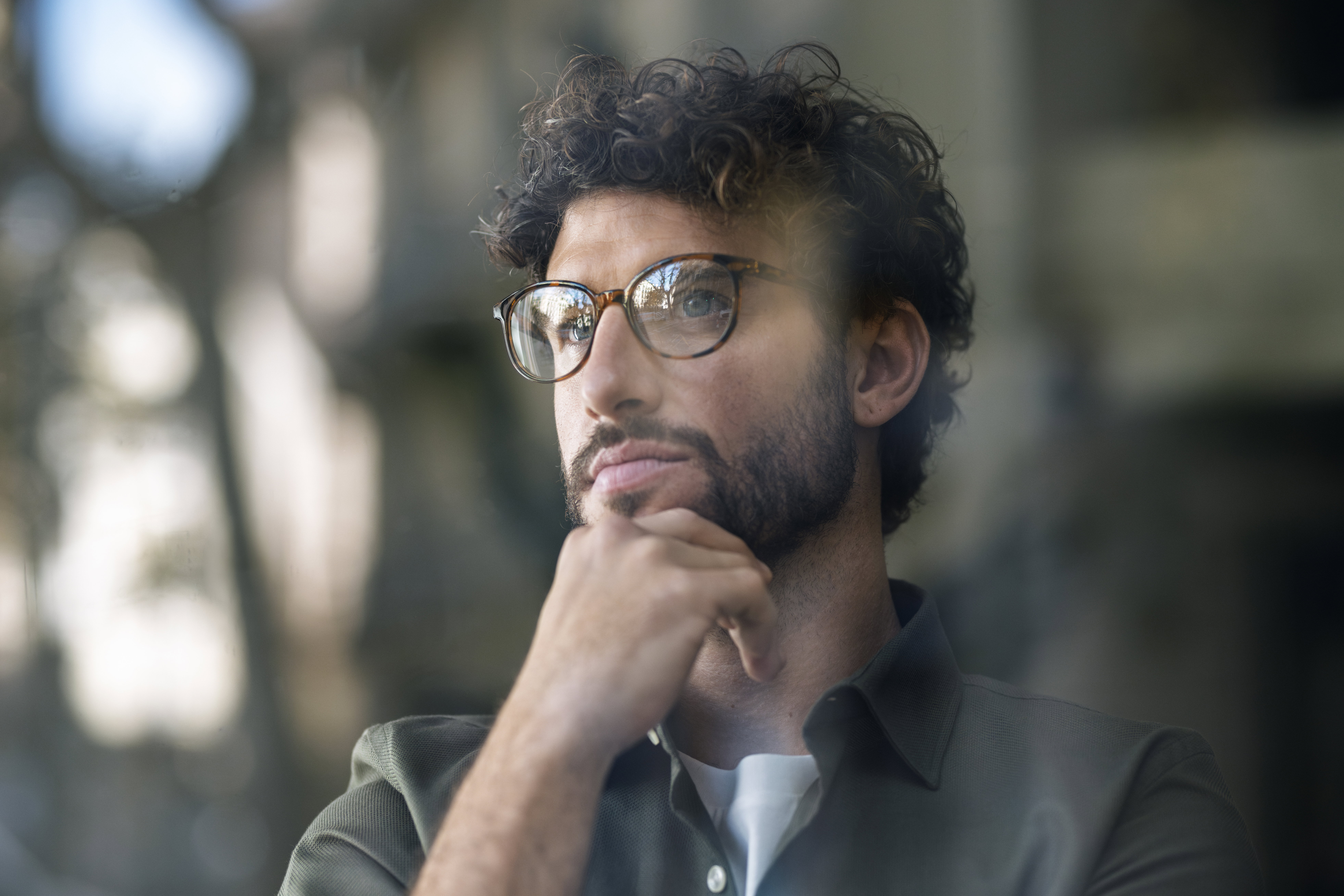 Thoughtful businessman wearing eyeglasses with hand on chin