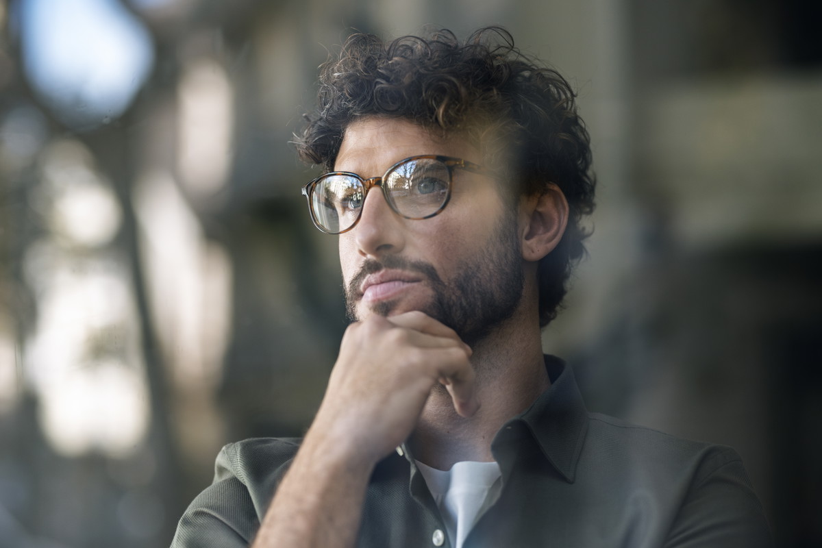 Thoughtful businessman wearing eyeglasses with hand on chin