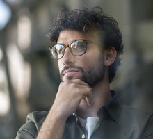 Thoughtful businessman wearing eyeglasses with hand on chin