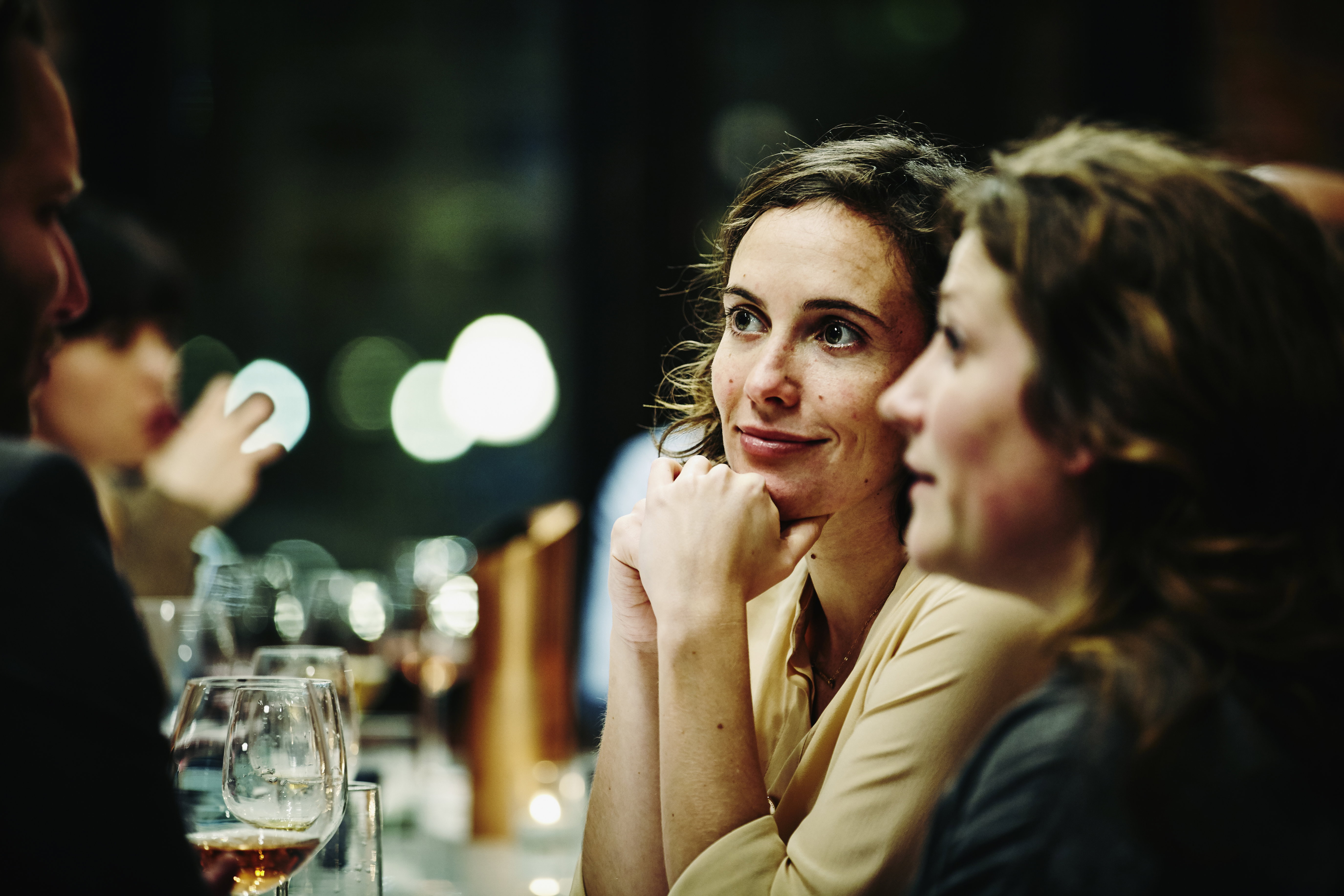 Smiling friends talking at dinner party