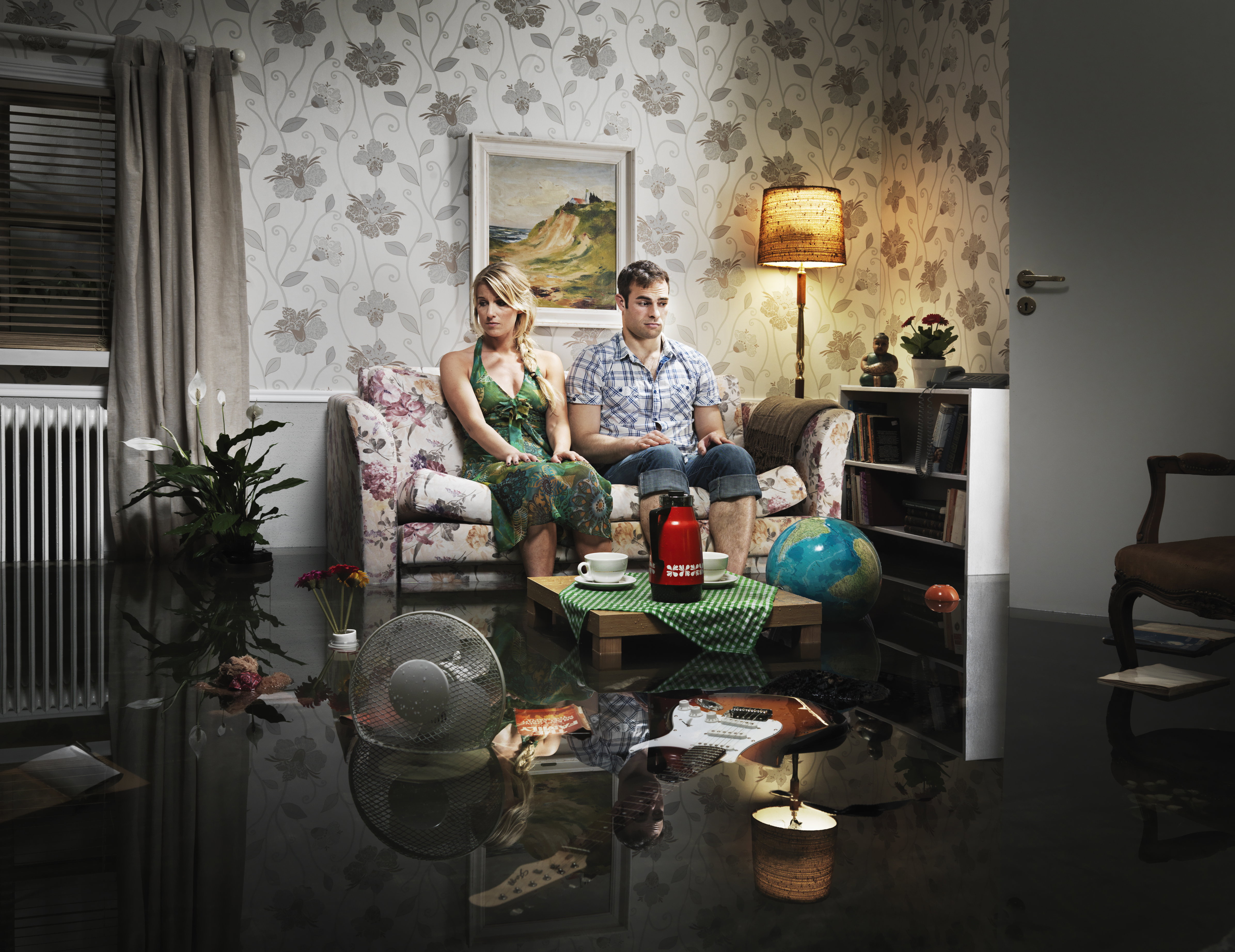 young couple in sofa in a flooded room