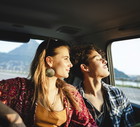 Young couple traveling by car, sunset light