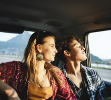 Young couple traveling by car, sunset light