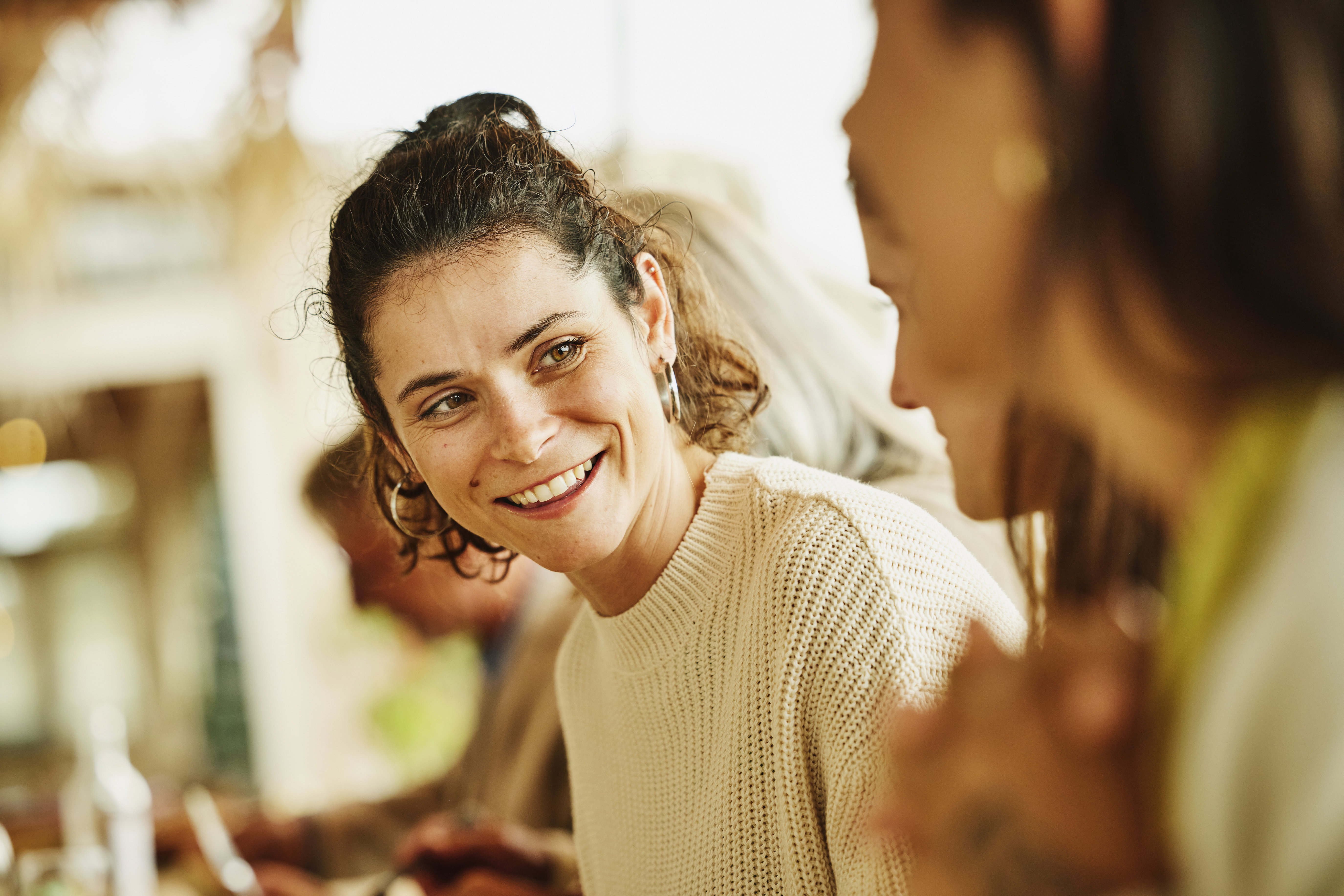 Medium shot woman in discussion with friends at wedding dinner