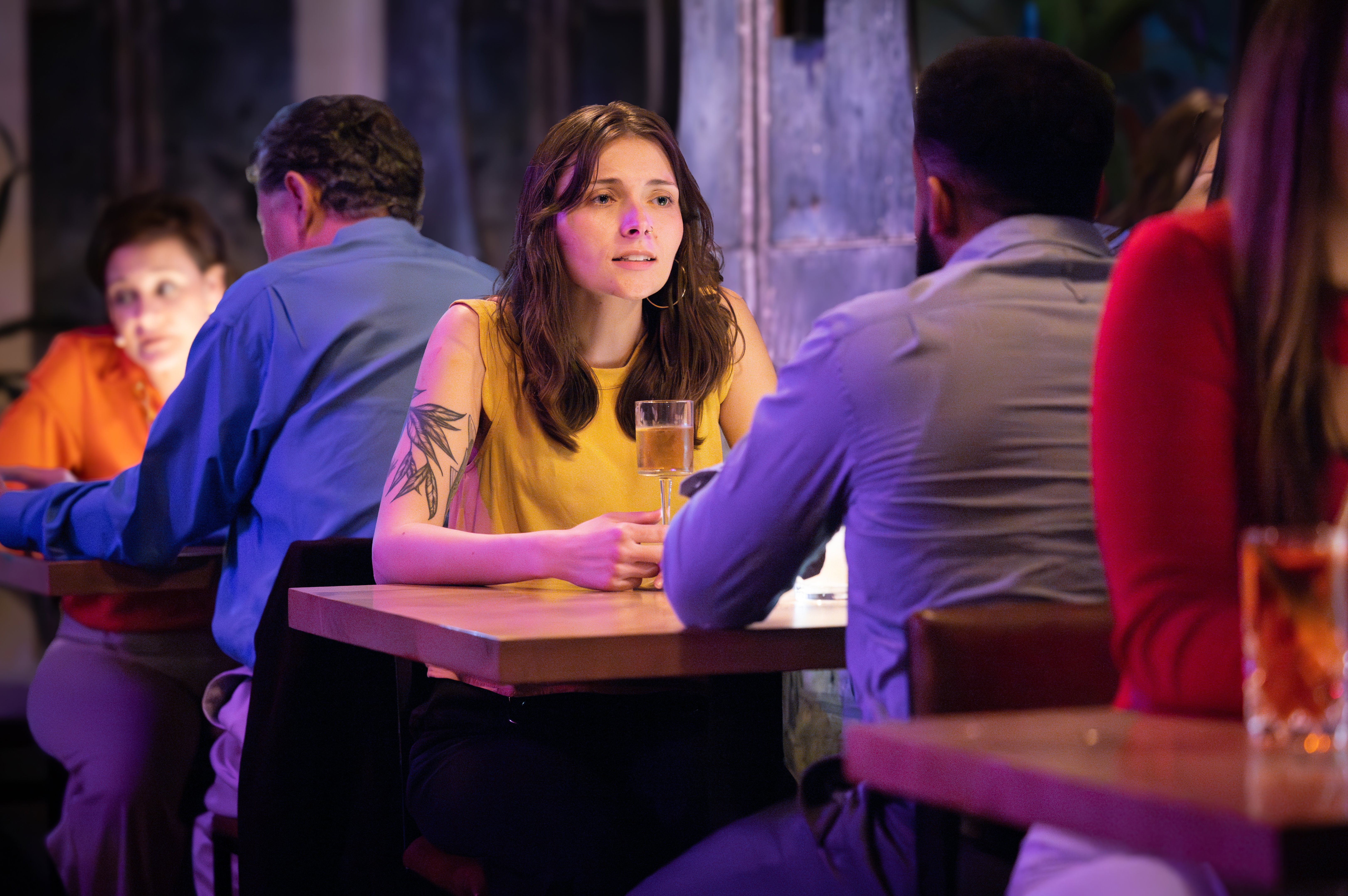A woman on a date in a stylish restaurant looks concerned