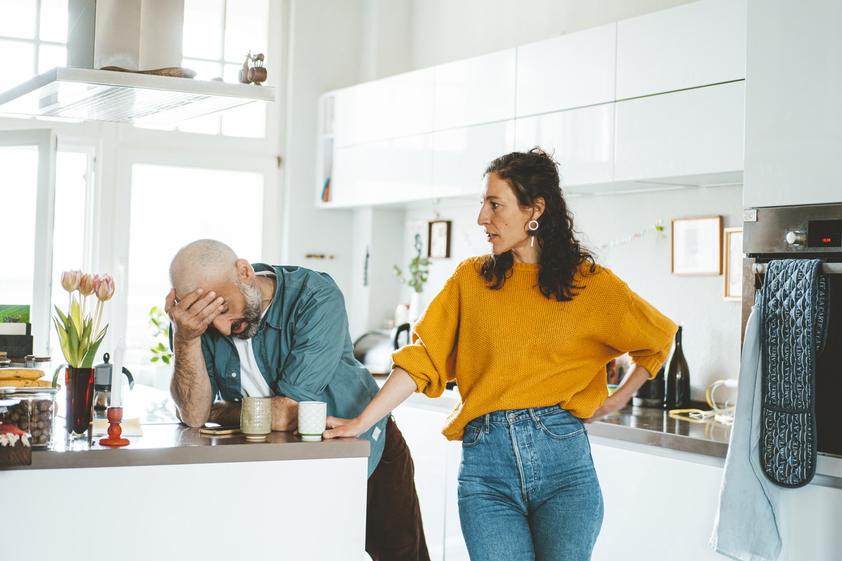 Serious woman arguing with man in kitchen at home