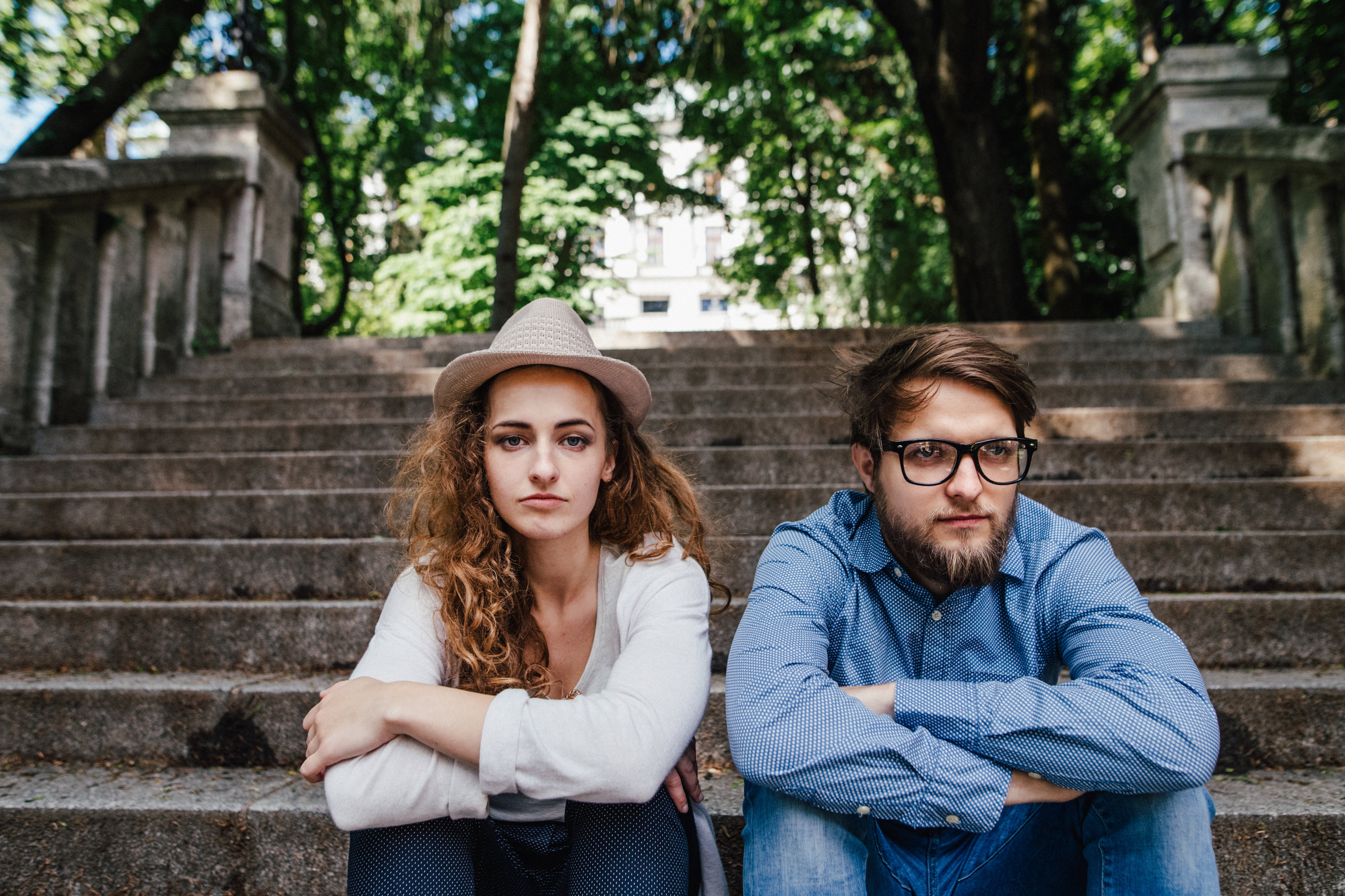 Couple after argument sitting on concrete stairs in city.