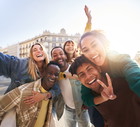 A group of cheerful students college friends taking a selfie as they travel through European cities.