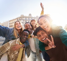 A group of cheerful students college friends taking a selfie as they travel through European cities.