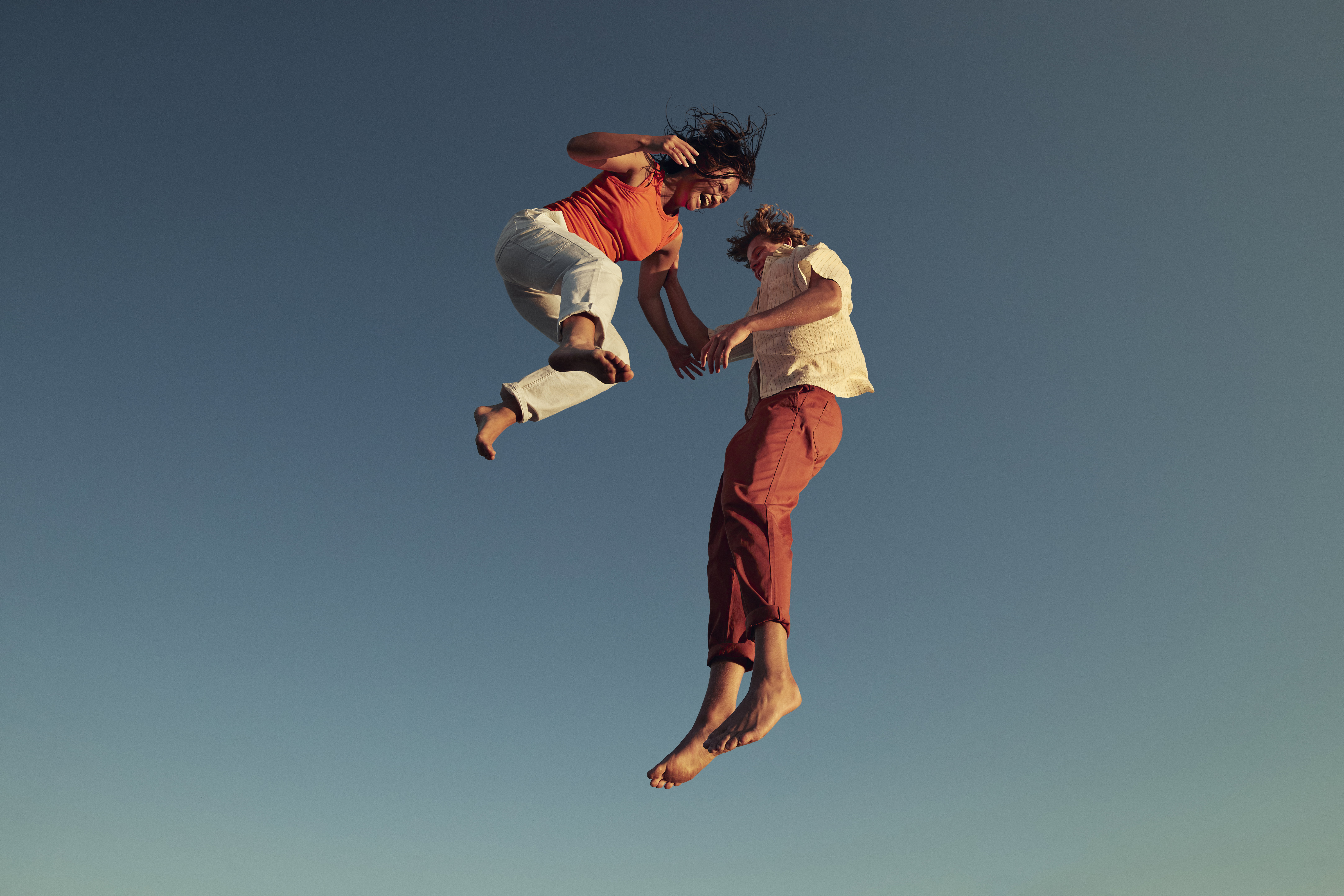 Cheerful friends jumping high up in mid-air