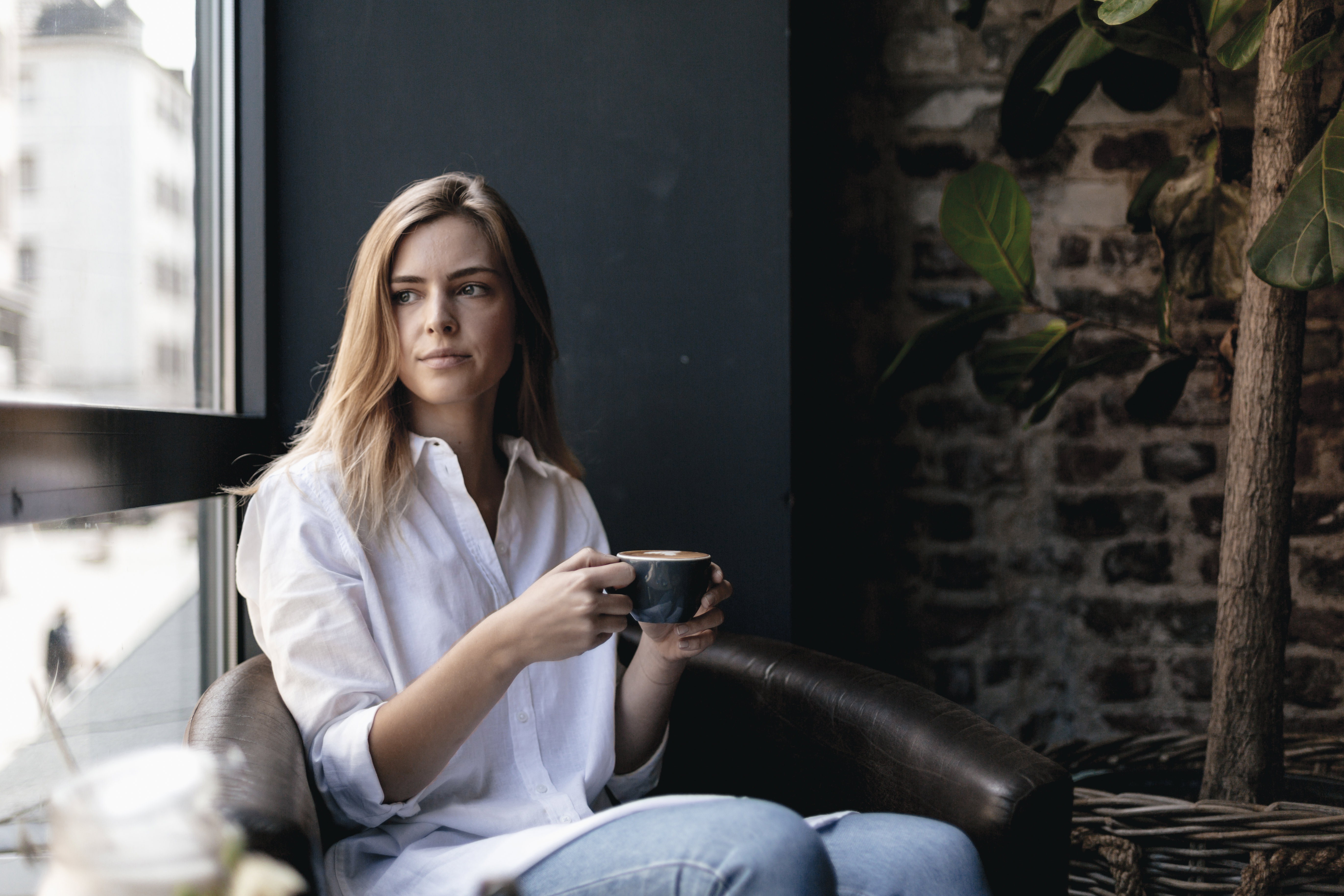 Young woman sitting in cafe, drinking coffee