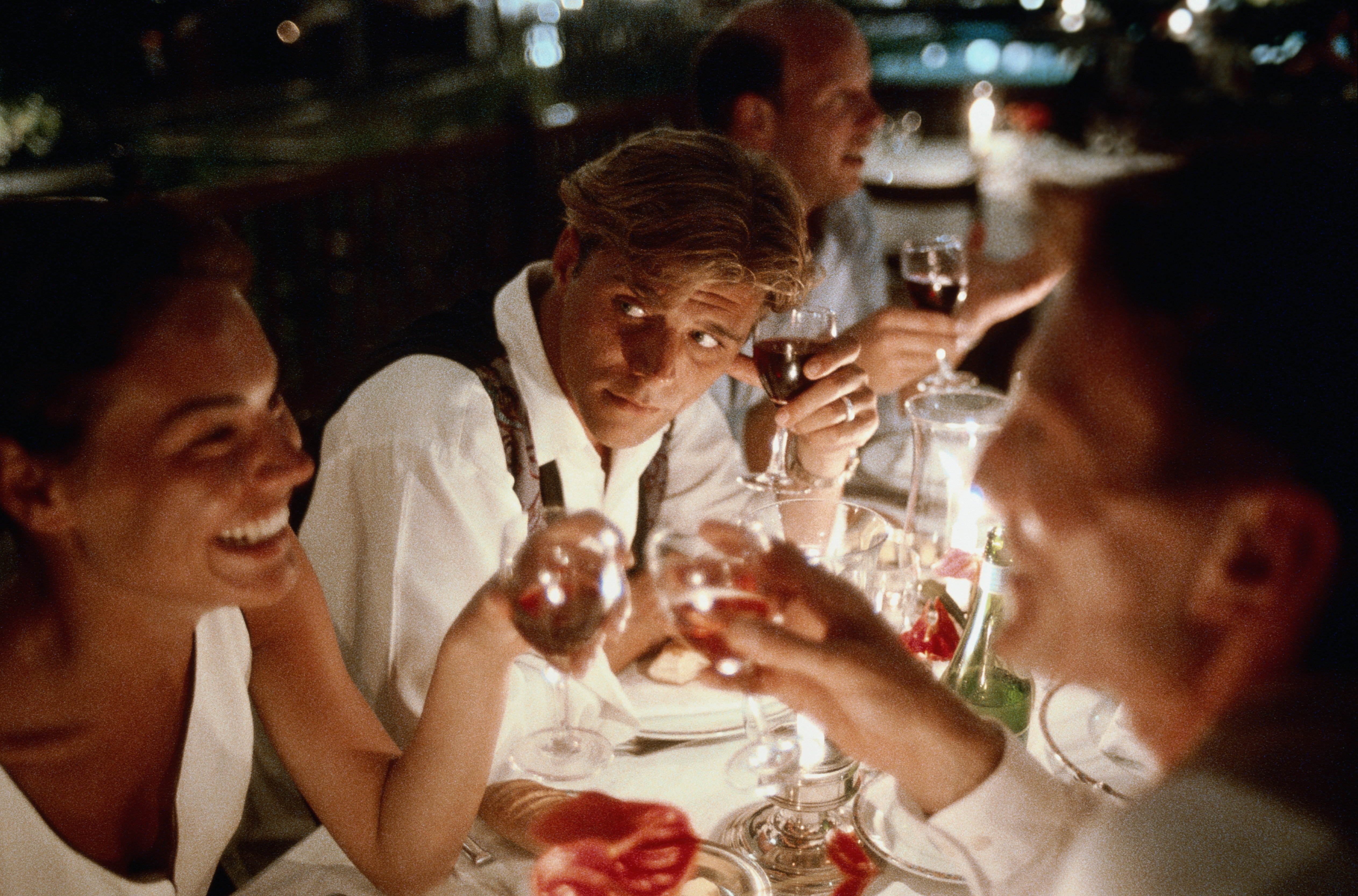 Group of friends making toast in restaurant at night