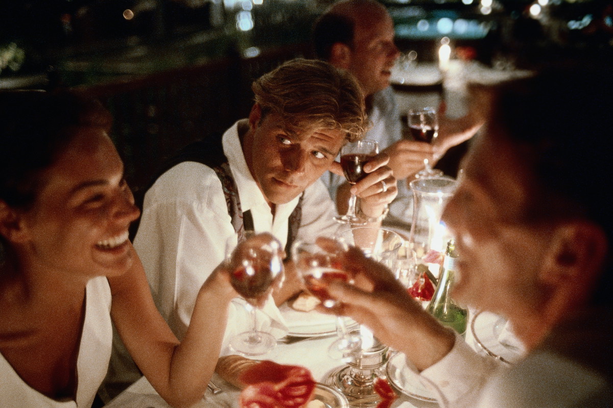 Group of friends making toast in restaurant at night