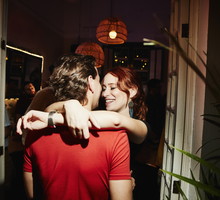 Smiling woman embracing boyfriend during party in night club