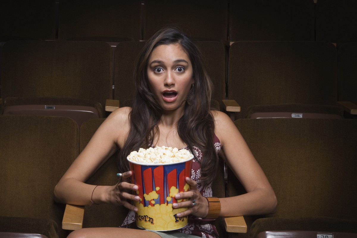 Scared woman sitting in movie theater
