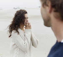 Serious brunette woman and man on the beach