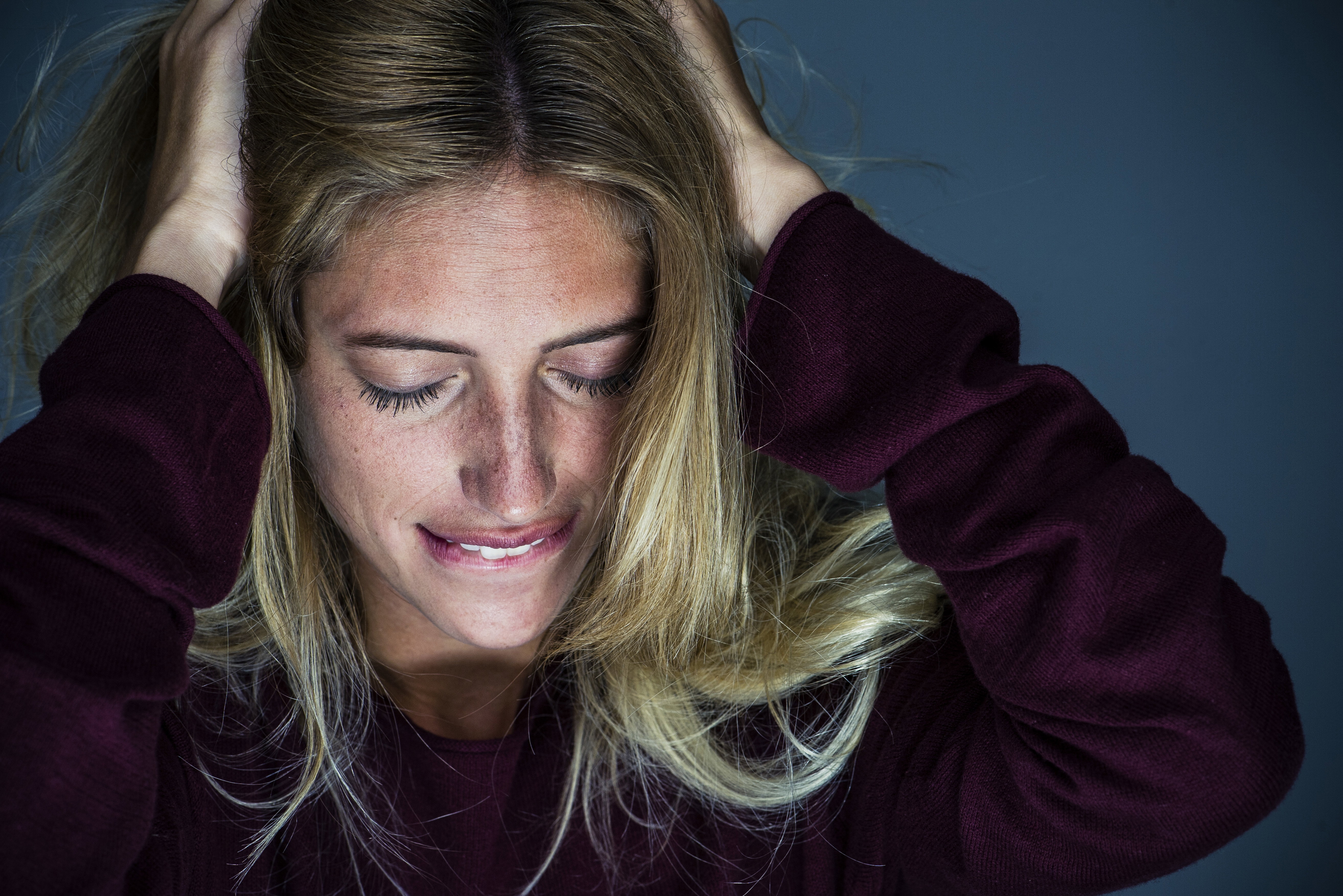 Upset young woman holding hand and biting lips