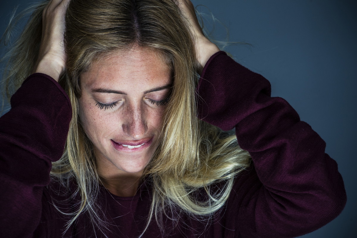 Upset young woman holding hand and biting lips