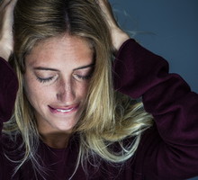 Upset young woman holding hand and biting lips