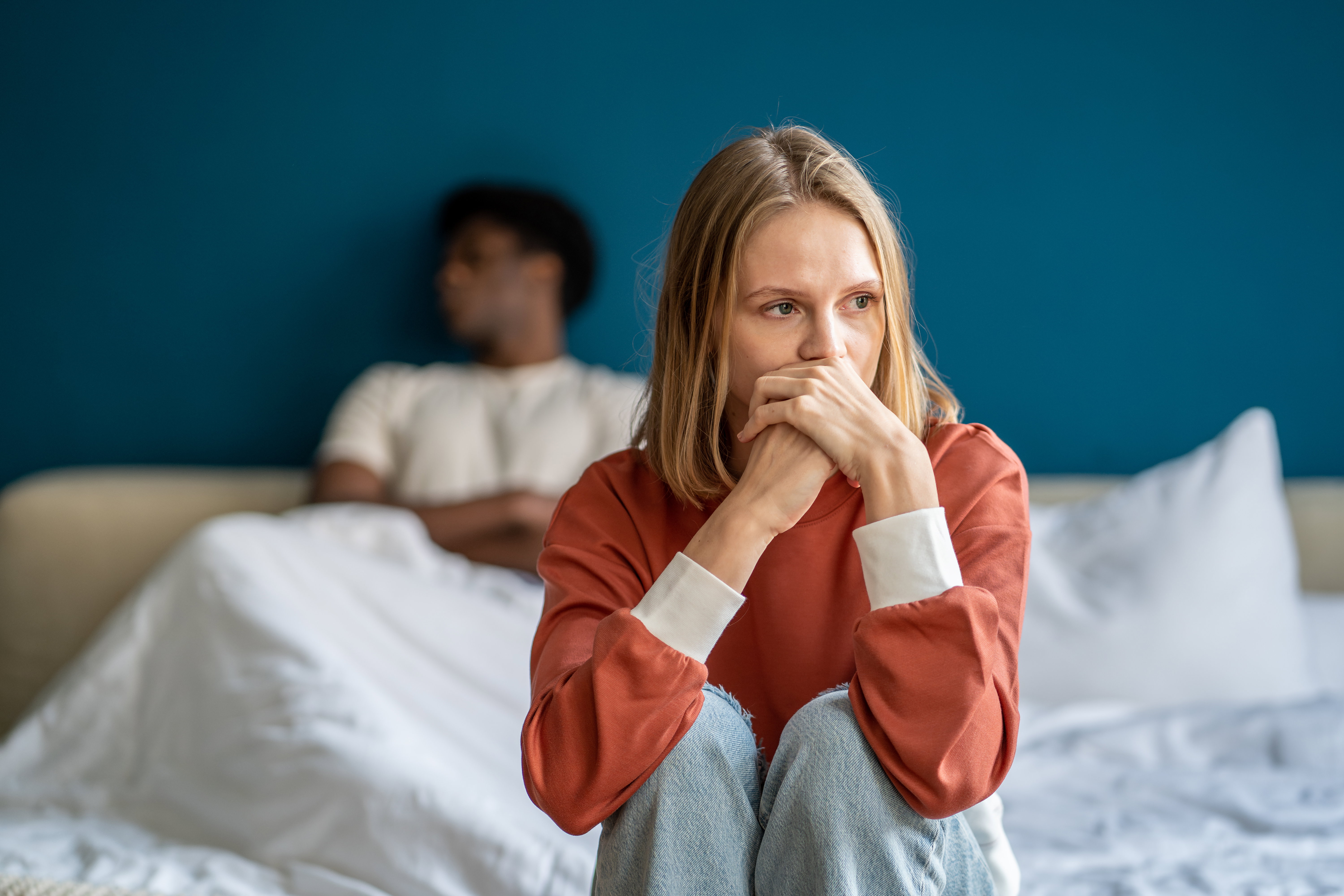 Unhappy multiracial couple in bed having problems and misunderstanding after quarrel, argument
