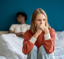 Unhappy multiracial couple in bed having problems and misunderstanding after quarrel, argument
