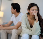 The Asian couple getting upset with each other in bedroom.