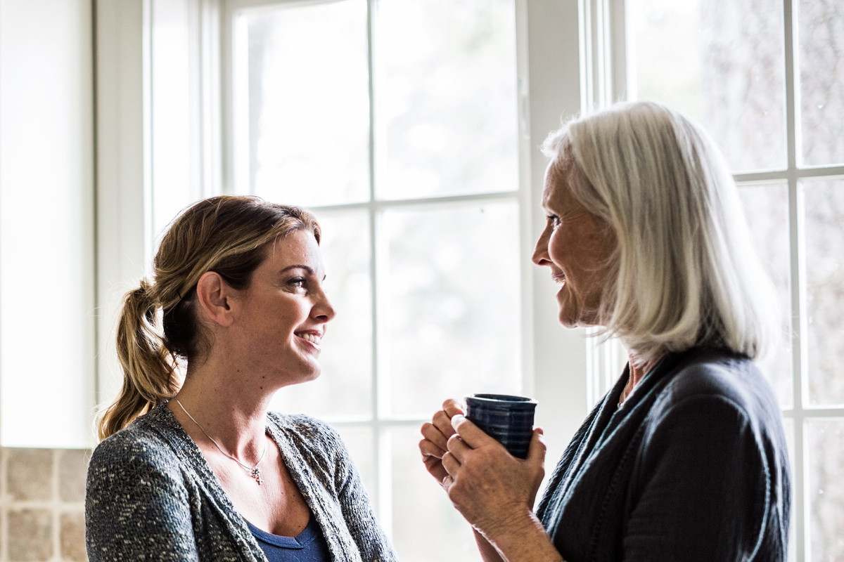 mother and daughter having coffee in kitchen