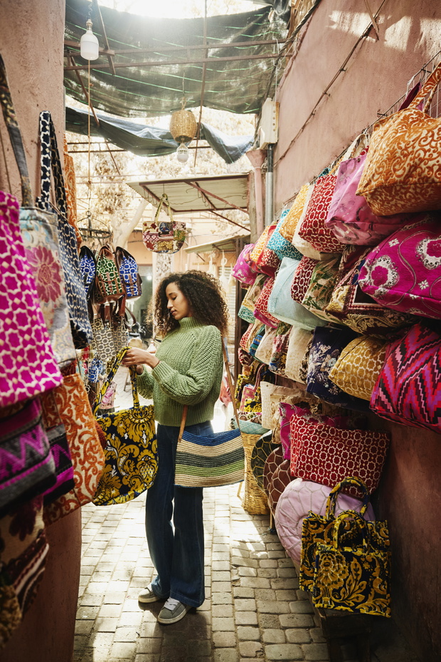 Wide shot of woman shopping for bag in the medina of Marrakech
