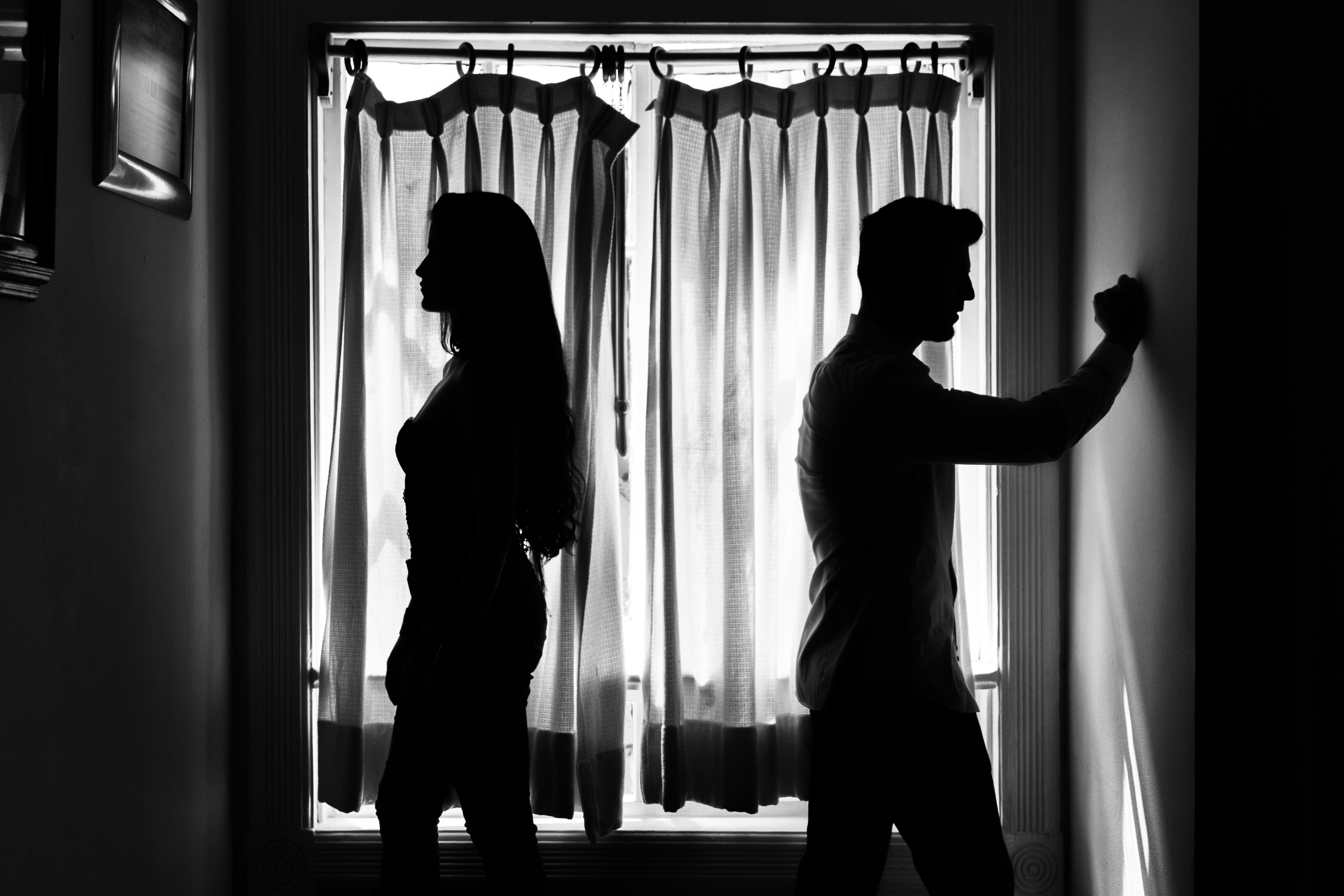 Silhouette of a young Mexican couple against a window