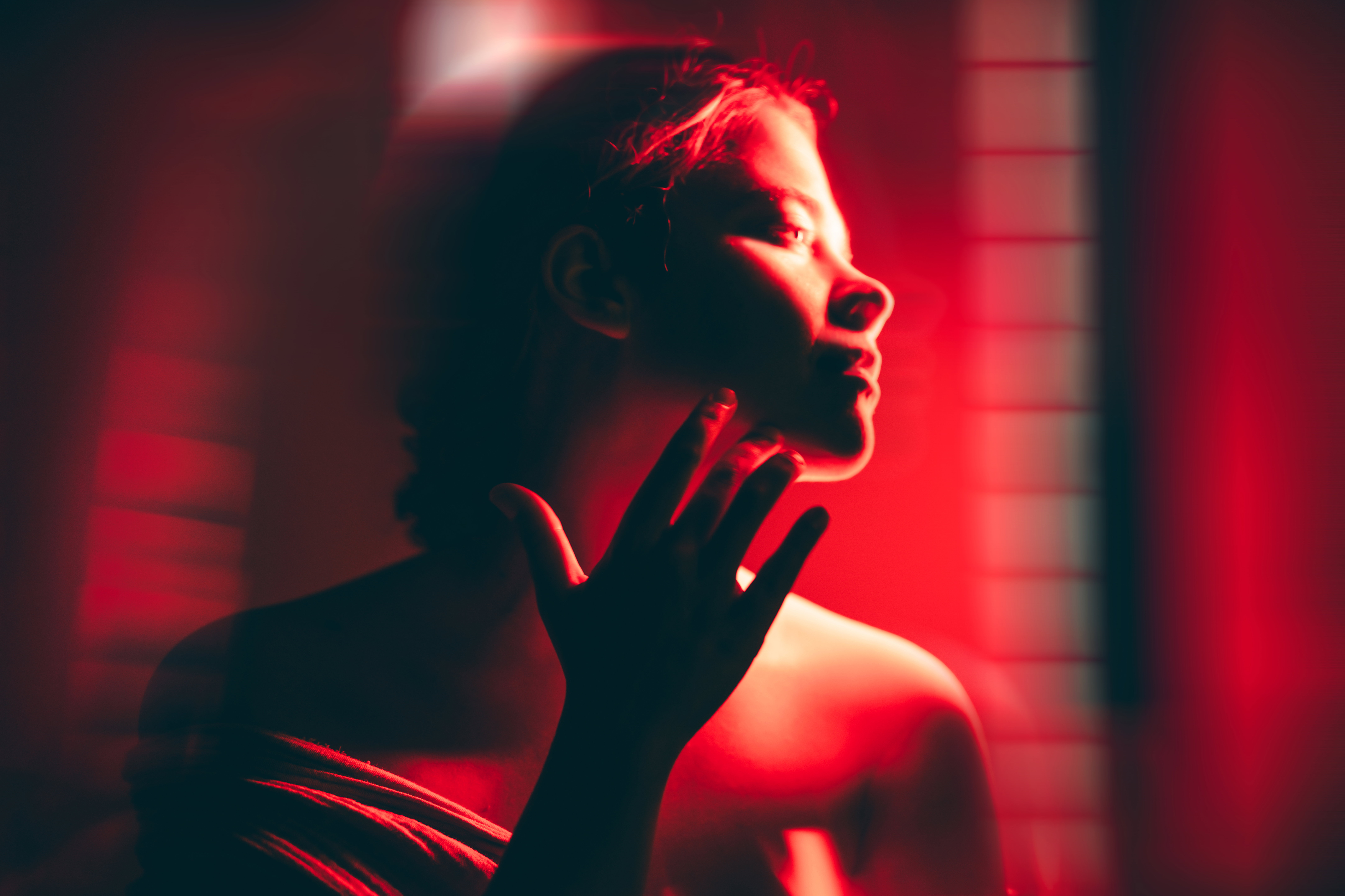 A woman doing full body red light therapy in a dark room