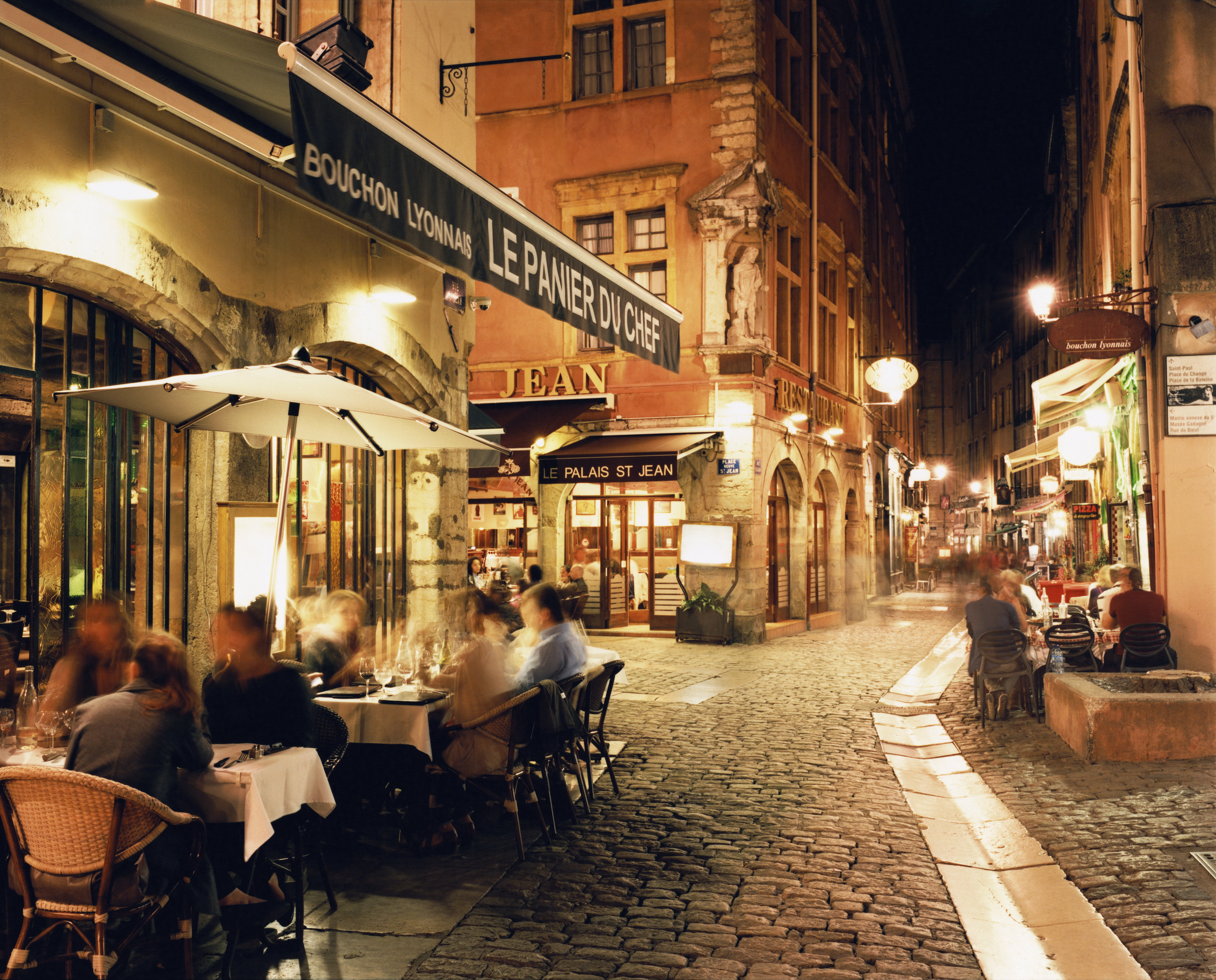 Lyon, People dining along cobbled street at night