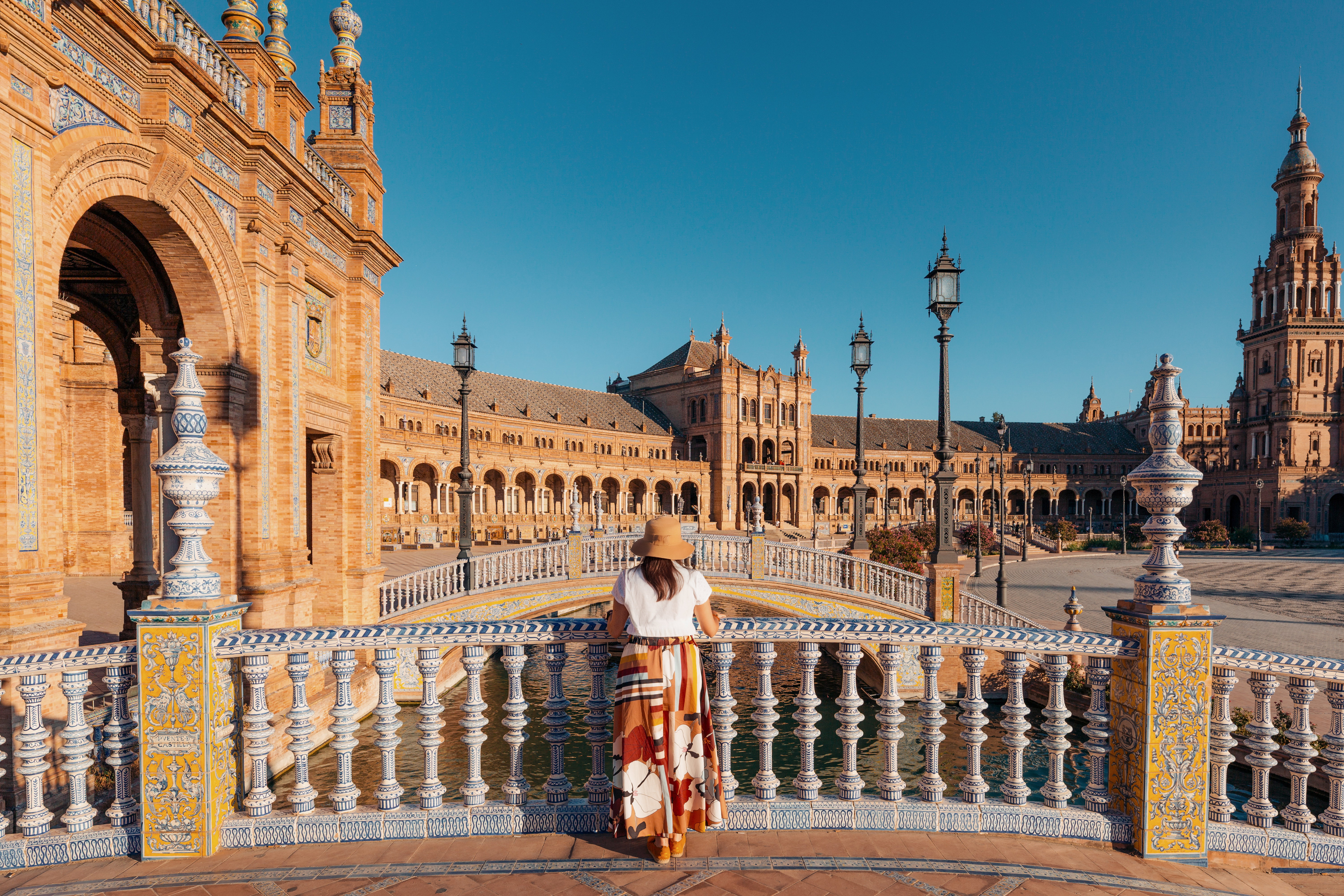 A woman traveler admires the beautiful Plaza de Espana in Seville