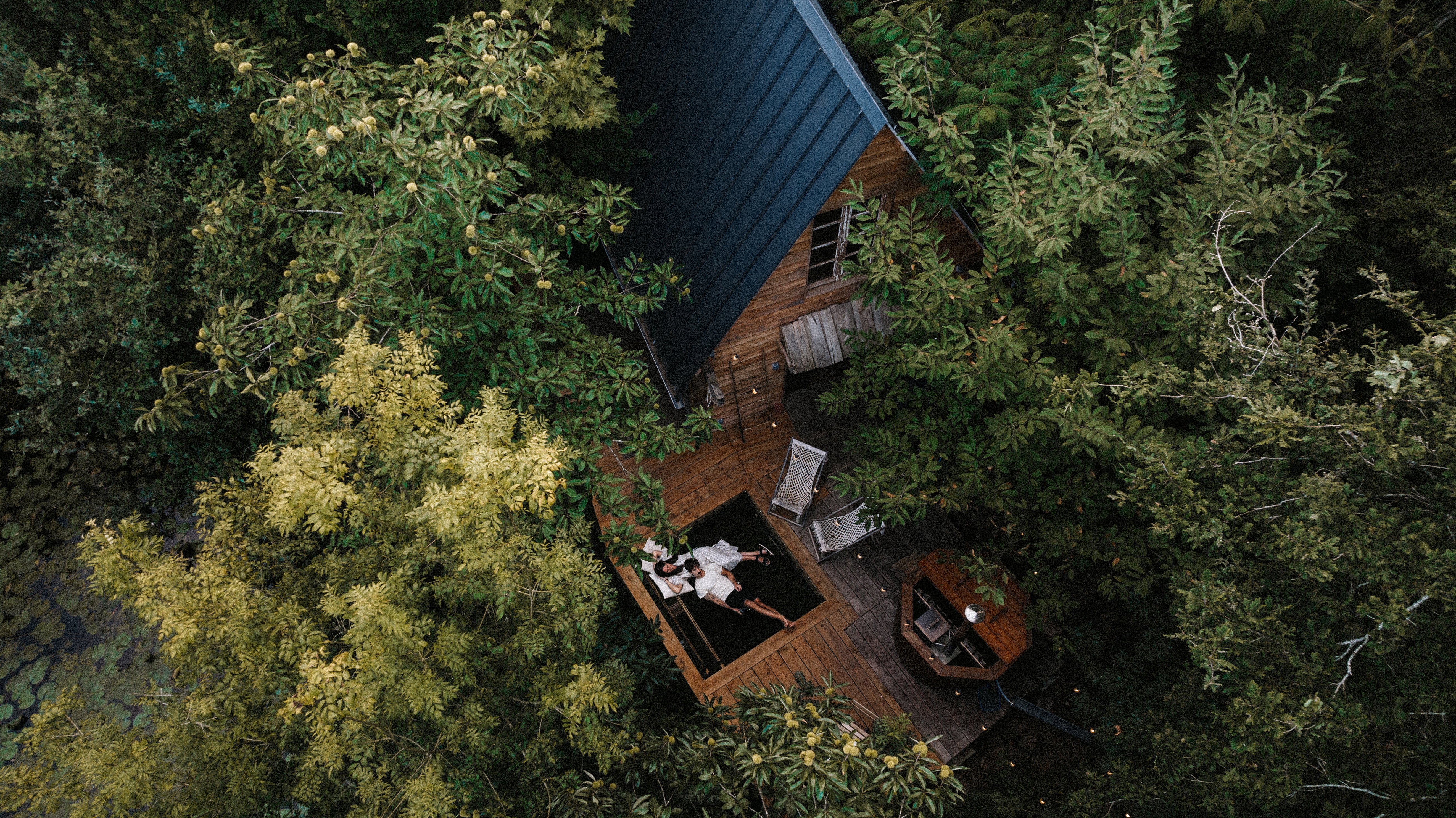 drone view of a couple in a wooden cabin
