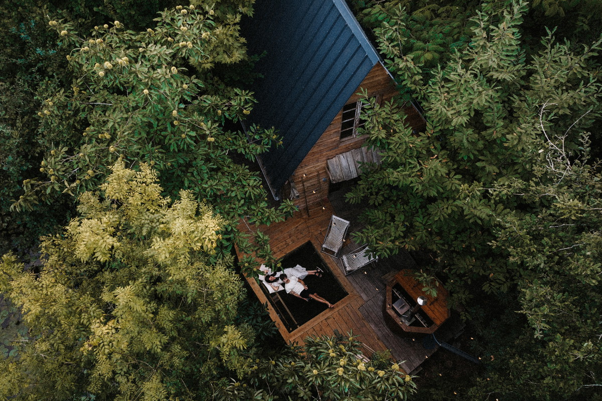 drone view of a couple in a wooden cabin