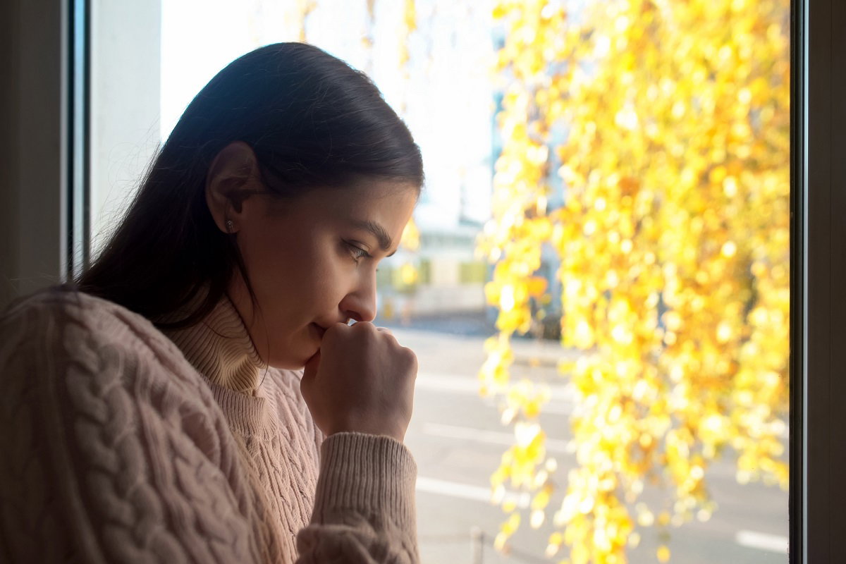 kobieta w oknie jesienią