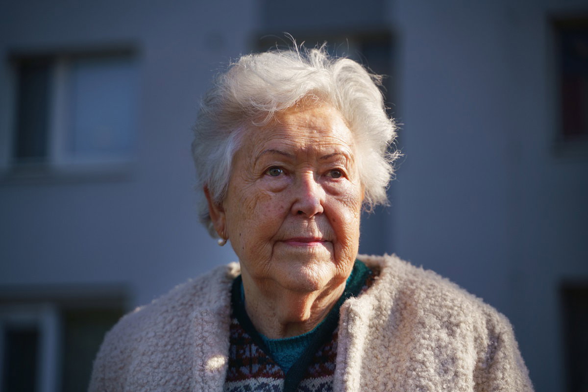 starsza kobieta na tle bloków