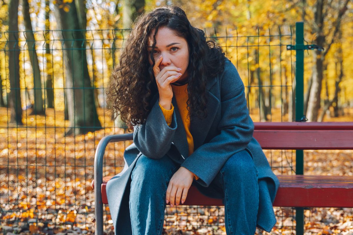 Załamana kobieta w jesiennym parku