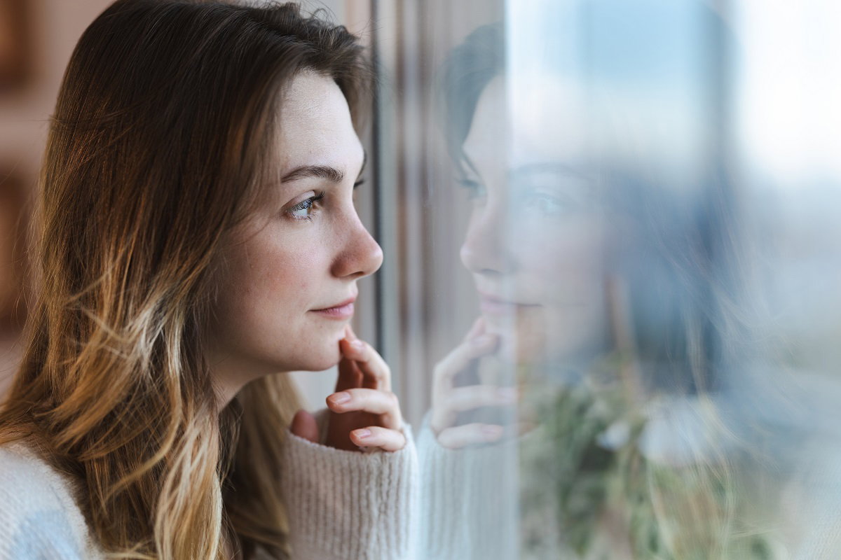 zamyślona kobieta w oknie