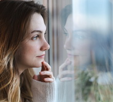 zamyślona kobieta w oknie