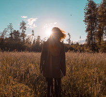 Wind blowing hair of woman standing in field