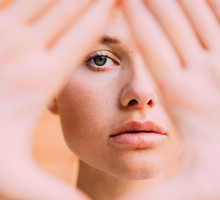 Portrait Of Young Woman Gesturing Over Face