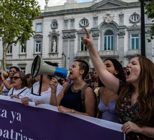 A group of women protesting with a banner reading 'Enough of