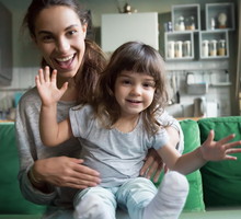 Happy mother and kid looking at camera recording videoblog, portrait