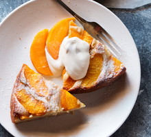 Two slices of peach cake on a plate served with yogurt.Top view